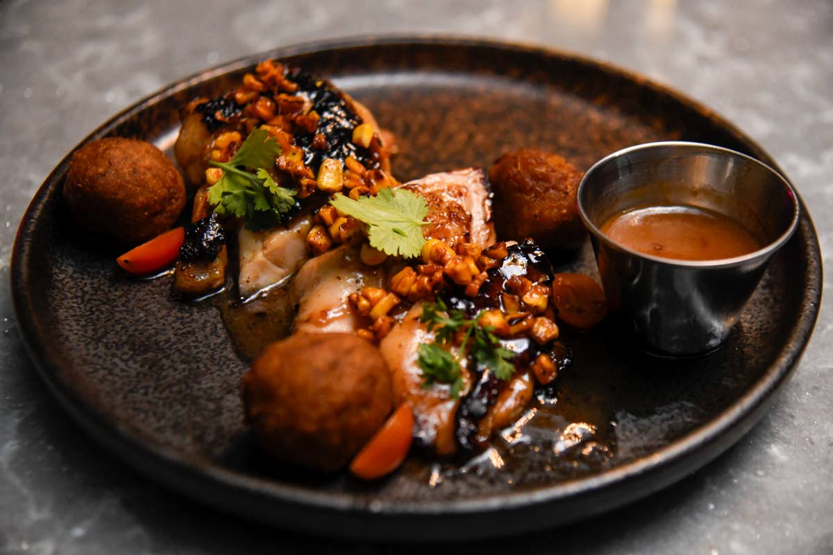 The fire-roasted chicken breast supreme is finished with a guava glaze and served with blistered corn and plantain balls.