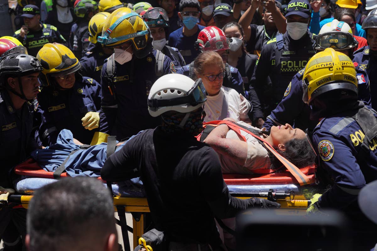 Rescue workers carry Diana Troncoso after pulling her from the rubble the day after an earthquake struck Pereira, Colombia, Tuesday.