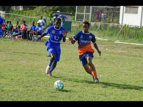 Kemar Beharie (right) of Dunoon Technical and Antonio Mitchell of Norman Manley High in a race for the ball during  an ISSA/Digicel Manning Cup match at the Excelsior High School in 2022. Dunoon won 2-1.