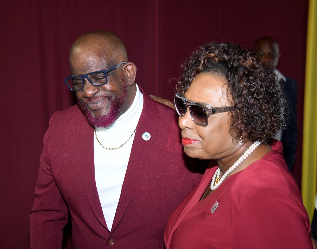 
Paul Francis, brother of Stephen Francis (left), and Olivia ‘Babsy’ Grange, minister of culture, gender, entertainment and sport, share a moment at the thanksgiving service for the late coach at the National Indoor Sports Centre yesterday.