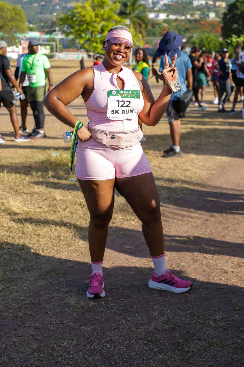 Joelle Dietrich brings pink power and playful energy to the route, throwing up deuces in her race-day look.