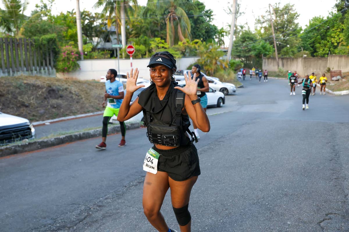 Chrisney Porteous waves to the lens as she completes the 5K stretch. 