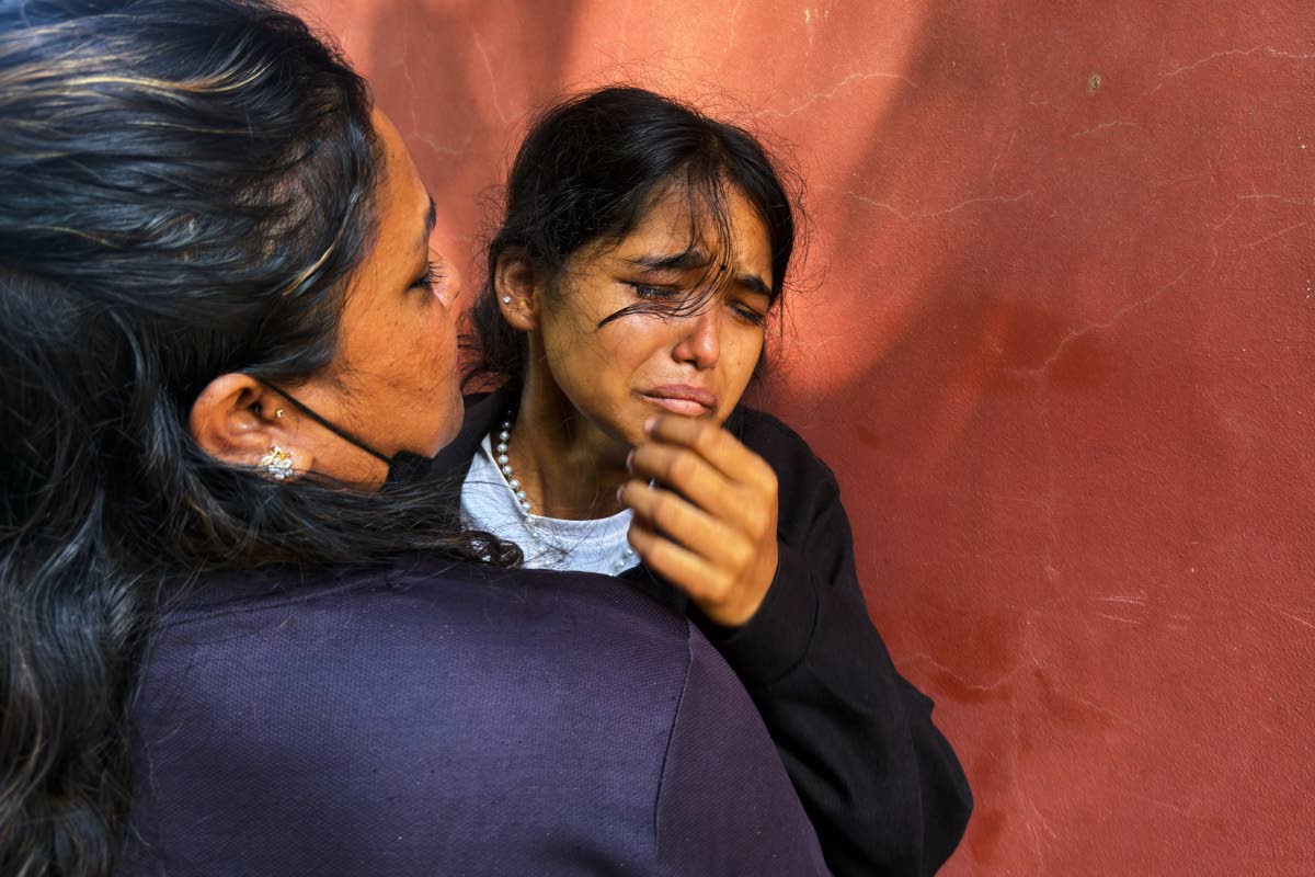 Jenisha (right) cries as she waits for news on her father missing after flash flooding in Nepal’s Nuwakot district on Friday.