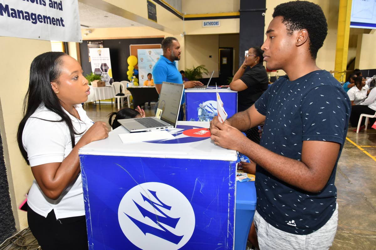 Russchanie Douglas (left), senior relationship manager at Mayberry Investments Limited, outlines early investment opportunities for Warren Scott, a new student at the University of Technology Jamaica. 
