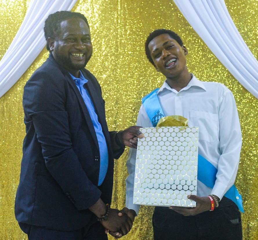 Saquana Grant (right), the Project STAR Youth Summer Leadership Camp King, receives a gift from Project STAR Community Coordinator Romel Grant.