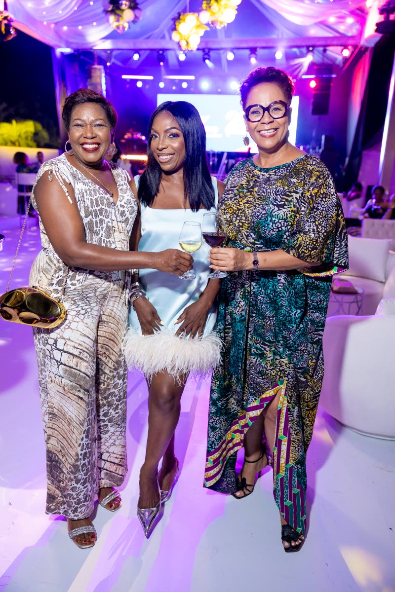 From left: Winsome Gibbs, branch manager for Jamaica, CG United, wears a sleeveless wide-leg jumpsuit as she poses with Donna Brown, chief executive officer of Caribbean Assurance Brokers, in a light blue strapless mini with a plush feather trim, and BCMG 