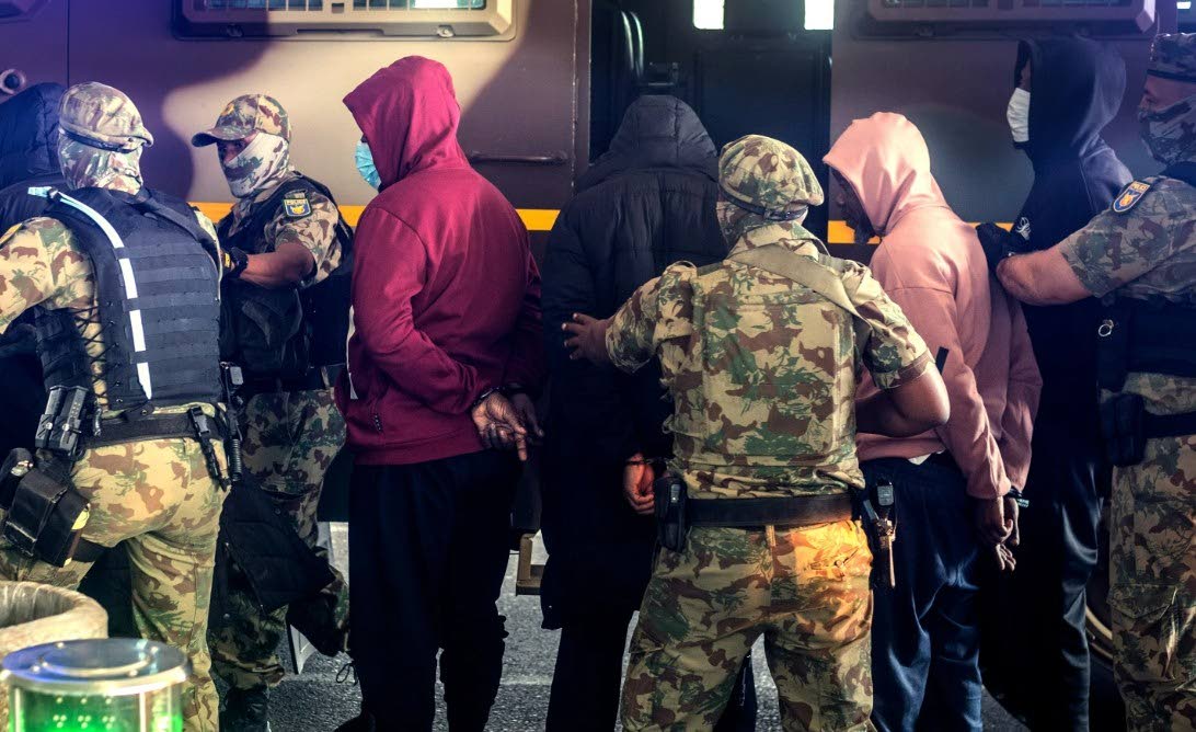 Members of the elite tactical police unit escort six Nigerian nationals being extradited to US for participating in romance scams, in Cape Town, South Africa, Friday, September 11, 2026.