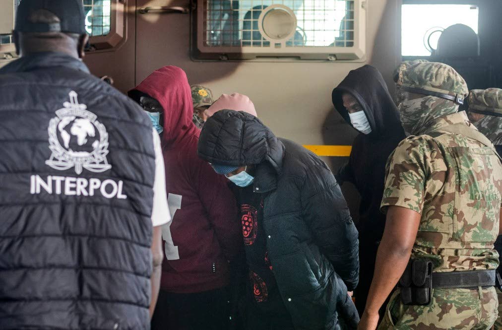 Members of the elite tactical police unit escort six Nigerian nationals being extradited to the US for participating in romance scams, in Cape Town, South Africa, Friday, September 11, 2026. 