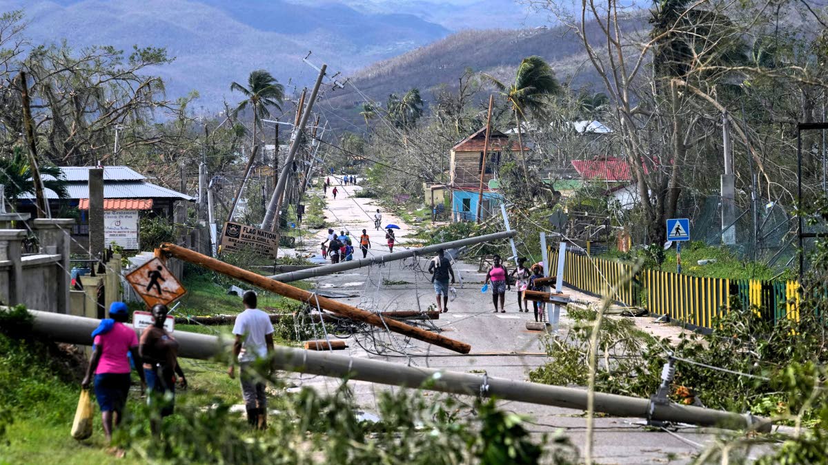 In this photo taken on October 29, 2025, residents are seen walking through Santa Cruz after Hurricane Melissa passed.