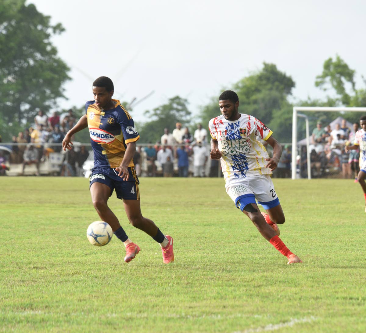 Munro College’s Aston Jones-Williams (left) dribbles ahead of chasing St Elizabeth Technical High player Shavarie Walker during their ISSA daCosta Cup second-round football match at Munro yesterday.