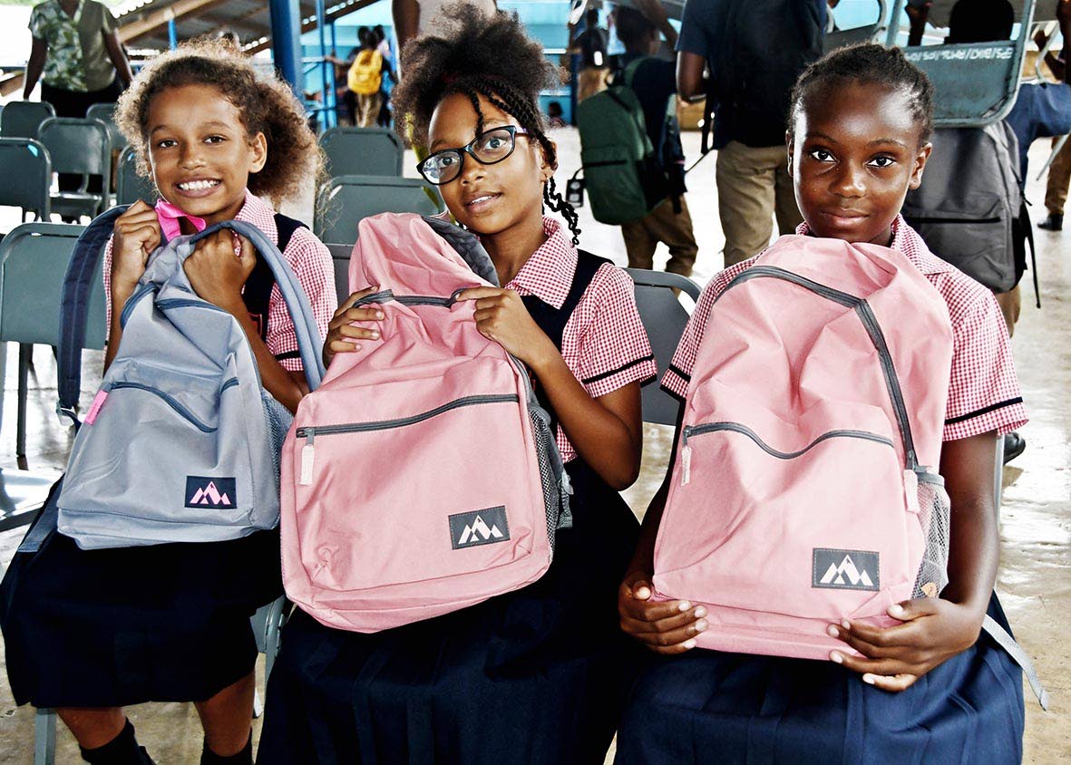 From left: Exchange Primary School students Sheena Ellis and Shenique Bennett, both in Grade Five, and Rasheeda Campbell of Grade Six, display the school bags and supplies they received from the Jamaica Real Estate Hub.