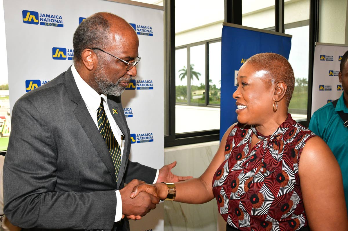 Earl Jarrett (centre), chief executive officer (CEO) of the JN Group greets Susan Powell, executive managing director and co-owner of Pow Pow’s Financial Services, during a business luncheon in St Ann, hosted by the JN Group on October 2. The luncheon fa