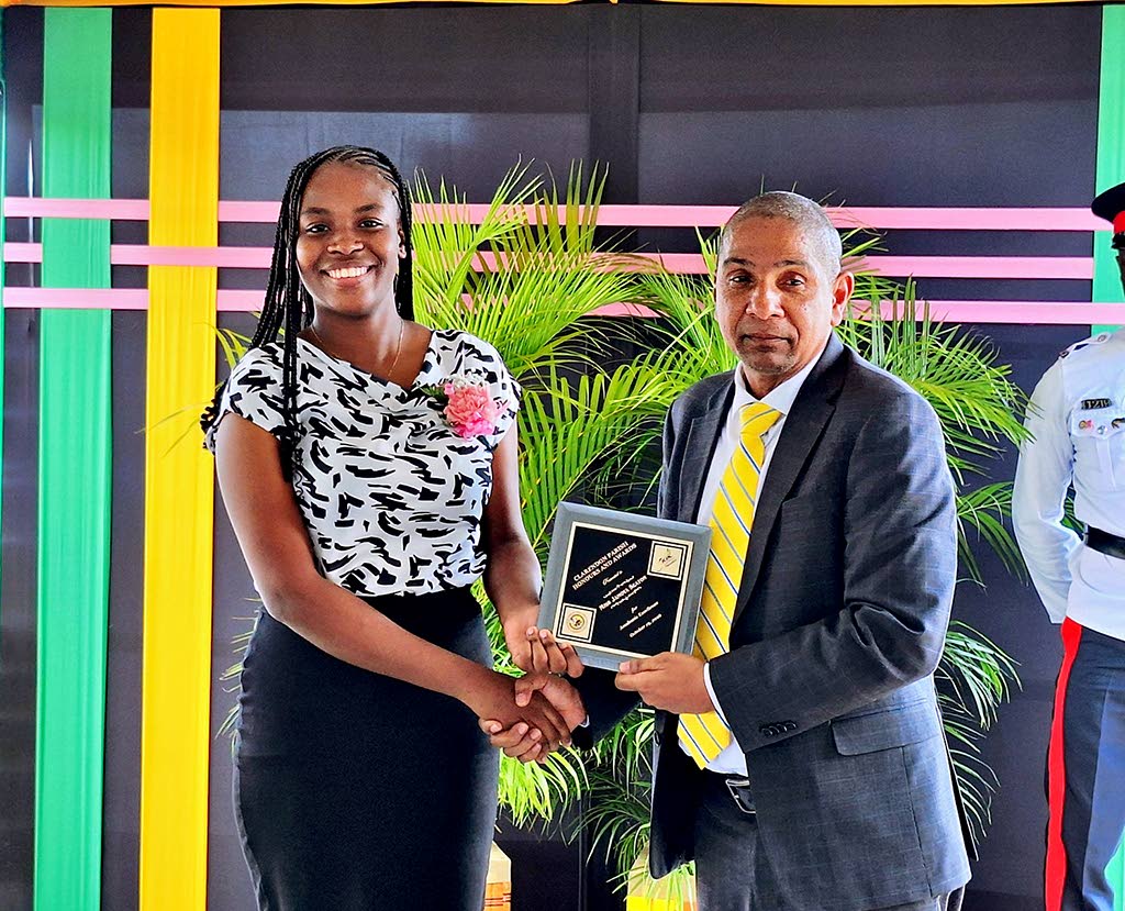 Seventeen-year-old Jamoya Seaton, the youngest among eight Clarendonians honoured at the parish’s National Heroes’ Day awards ceremony, receives her award from Clarendon Central Member of Parliament Delroy Williams.