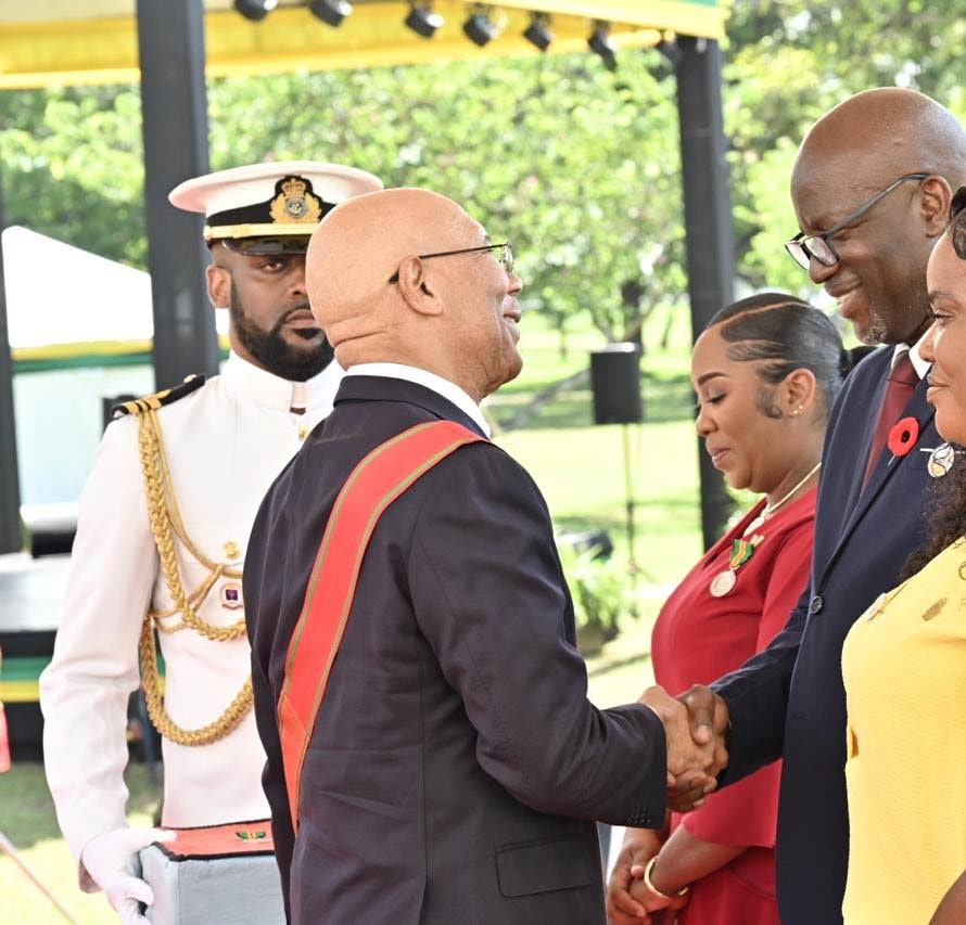Governor General Sir Patrick Allen (left) congratulates Scean Barnswell (second right) and wife Danielle on their national awards, which he presented to them on Monday. Looking on is fellow awardee Susan Higgins.