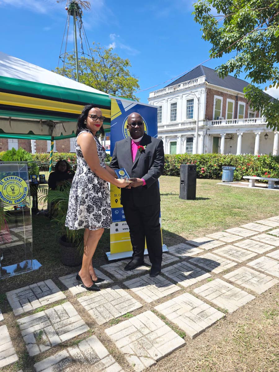 Apostle Audley Arnold receives his award from Tamika Small, chief financial officer of the St Catherine Municipal Corporation, during the Heroes Day civic function.