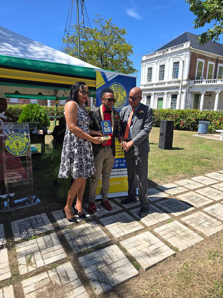 Veteran music selector Roger 'Master Raj' Maragh receives his award from Mayor Norman Scott and Tamika Small, chief financial officer of the St Catherine Municipal Corporation.