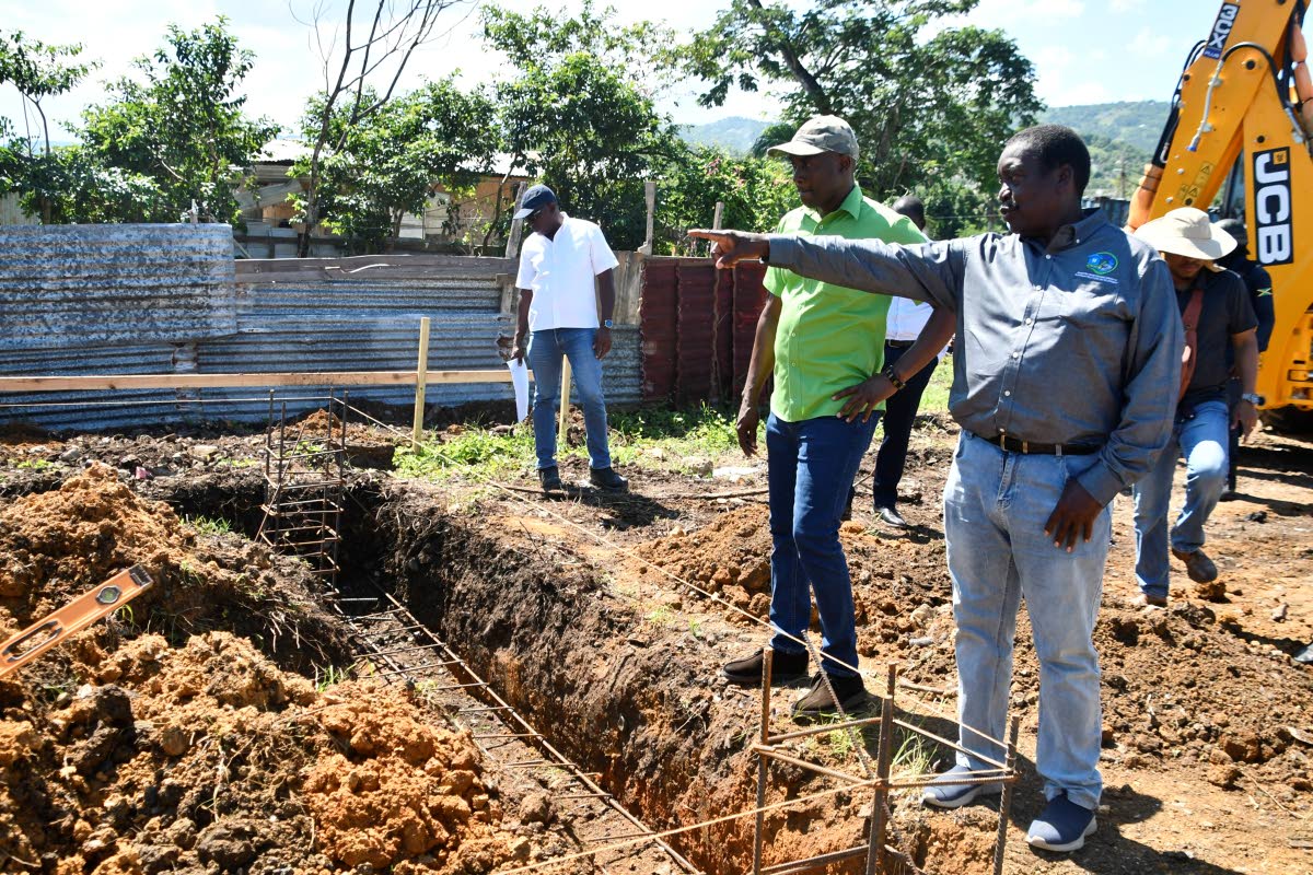 Minister without Portfolio in the Ministry of Economic Growth and Infrastructure Development with Responsibility for Land Titling and Settlements, Hon. Robert Montague (right, foreground), visits a container home construction site at Wanstead Road, St Eliz