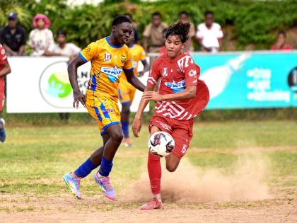 Luke Stanley (right) of Campion College tries to dribble by Streme Cha of Papine High School during their ISSA/WATA Manning Cup football match at Campion College in St Andrew yesterday. Campion won 1-0.
