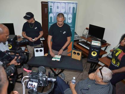 Marcus Price (centre) explains how to use the EP-40 drum machine to the attendees at Teenage Engineering presentation at Alpha Boys’ School on Monday. At right is singer Etana, and beside her, seated, is veteran producer and sound system man, King Jammy.