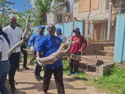 Desmond McKenzie (right), minister of local government and community development, and Dr Dayton Campbell left), member of parliament for Eastern Westmoreland, lead by example yesterday, assisting in removing debris to help restore community spaces in the p