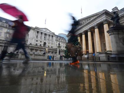 Pedestrians pass the Bank of England in London, as the Monetary Policy Committee (MPC) will publish their decision on interest rates, Thursday, December 18, 2025. 