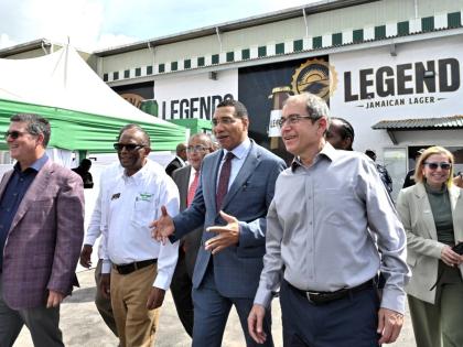 Prime Minister Dr Andrew Holness (centre) makes a point on a tour with William Mahfood (left), chairman of Wisynco Group; Devon Reynolds, director of manufacturing; Anthony Hylton, opposition spokesperson on industry, investment and logistics; Andrew Mahfo