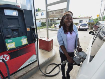 Alesha pumping gas at at Willis Gas Station in Cave Valley, St Ann, last week. She recalled that days after the passage of Hurricane Melissa last October, all she could see was water when she looked down at the town.