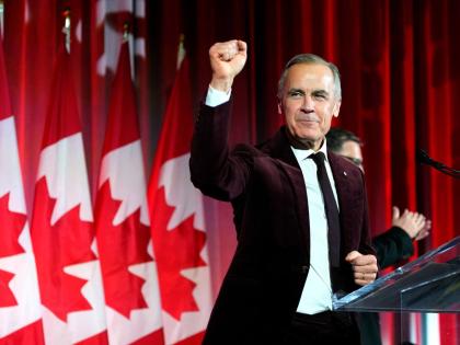 Canada's Prime Minister Mark Carney pumps his fist as he arrives to deliver remarks at the Liberal caucus holiday party in Ottawa.