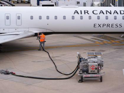 FILE - A worker fuels an Air Canada jet at DFW International Airport in Grapevine, Texas, Tuesday, April 14, 2026. (AP Photo/LM Otero, File)