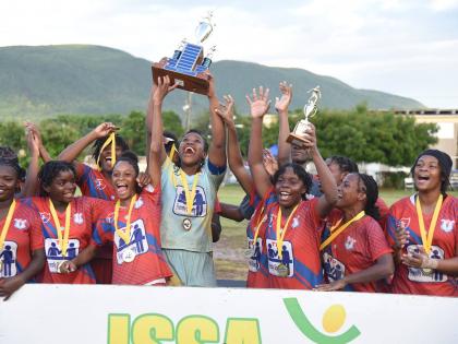 Members of the Camperdown High football team celebrate with the championship trophy after defeating defending champions Excelsior High in the ISSA high school girls’ football final at Wolmer’s Girl’s yesterday.