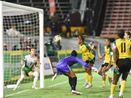 Reggae Girlz captain, Khadija Shaw (right), looks on as her header goes toward Guyana’s Rylee Traicoff during their Concacaf W Qualifier inside the National Stadium yesterday.