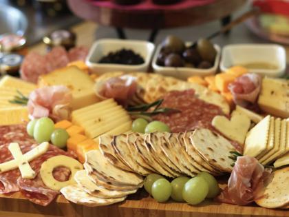 An arrangement of crackers, cheeses, meats, fruits and spreads is prepared for guests at a gathering of friends at an apartment in Flagstaff, Arizona.