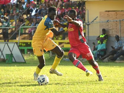 Racing United’s Odane Nish (left) tries to stop Montego Bay United’s Owayne Gordon from rounding him during their Jamaica Premier League game at Jarrett Park in Montego Bay yesterday. 