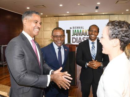 Keith Levy (left), managing director (interim) at JN Bank, makes a point to Minister of Foreign Affairs and Foreign Trade, Senator Kamina Johnson Smith (right), as she greets legacy sponsors and guests during the launch of the 11th biennial Jamaica Diaspor