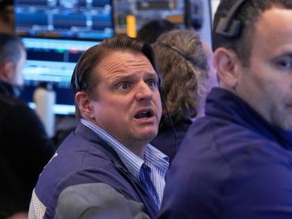 Trader Michael Milano, left, works on the floor of the New York Stock Exchange, Monday, April 20, 2026. 
