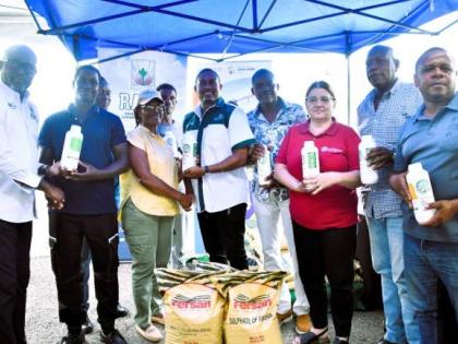 Minister of Agriculture, Fisheries and Mining, Floyd Green (centre), Representative of the Food and Agriculture Organization (FAO) of the United Nations in Jamaica, the Bahamas and Belize, Dr Ana Touza (third right), present farmers with agricultural input