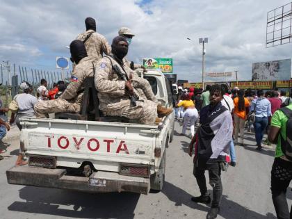 National Police patrol alongside a march by factory workers demanding a salary increase in Port-au-Prince, Haiti, Monday, April 13, 2026. (AP Photo/Odelyn Joseph)