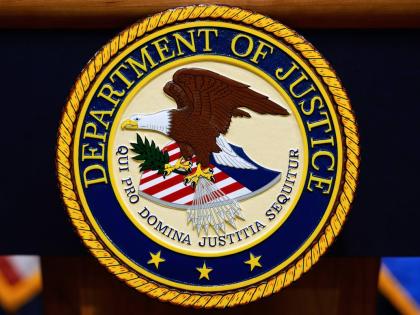 The US Department of Justice logo is seen on a podium before a news conference at the Justice Department in Washington, on May 6, 2025. (AP Photo/Julia Demaree Nikhinson, File)