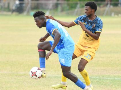 Tyrone Mullings of Racing United FC (right) attempts to tackle Sergei Ferguson of Molynes United FC during a Jamaica Premier League fixture at the Ferdi Neita Sports Complex in Portmore, St Catherine, yesterday. Molynes came away 2-1 winners.
