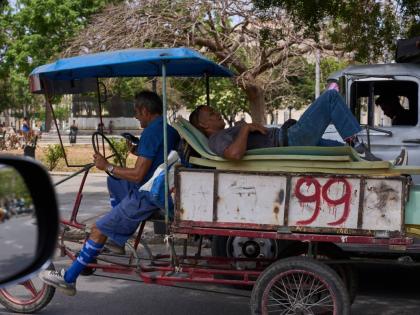 A man rests on mattresses atop a bicycle trailer in Havana, Wednesday, April 22, 2026. (AP Photo/Ramon Espinosa)