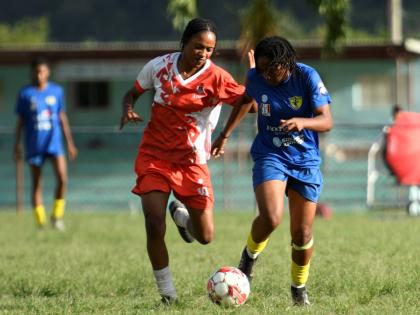 Ksystina Patterson of UWI women’s FC (left) attempts to tackle Kai Phillips of Real Mona FC during the Jamaica Women’s Premier League fixture at UWI Mona Bowl yesterday. Mona won 2-0.