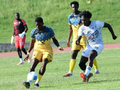 Jimoy Jones (left) of Racing United shields the ball from Cavalier’s Chad James during yesterday’s Jamaica Premier League match at the Stadium East field. Cavalier won 2-0. 
