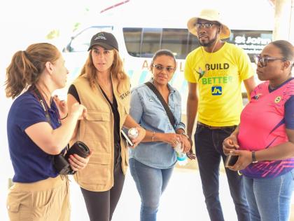 Members of the Corus International team, Amy Vu (left) and Emily Grose (second left), engage in conversation with Claudine Allen (centre), general manager of the JN Foundation; Omar Wright (second right), lead for environment and community development pro
