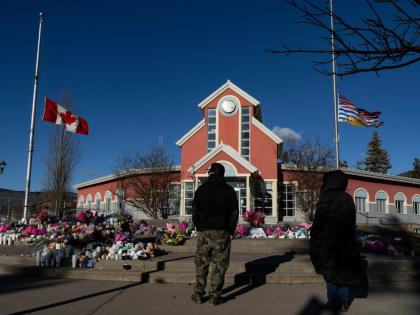  People pay their respects at a memorial on the steps of the Town Hall following a vigil the previous day in Tumbler Ridge, B.C., Saturday, February 14, 2026. (Christinne Muschi/The Canadian Press via AP, file)