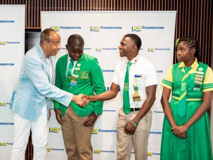 Michael Lee-Chin (left), chairman, NCB Financial Group Limited, greets Head Boy Richard Simpson(second left); Jabari Mannings, second deputy head boy; and Layla Price, sub prefect (all members of the school leadership of Old Harbour High) during a recent M