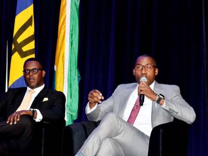 Hugh Grant (right), president and chief executive officer of the Jamaica Public Service, and Stephen Price, vice-president and general manager of FLOW Jamaica, speak on a panel during the Utility Service Providers round-table at the OOCUR 20th anniversary 