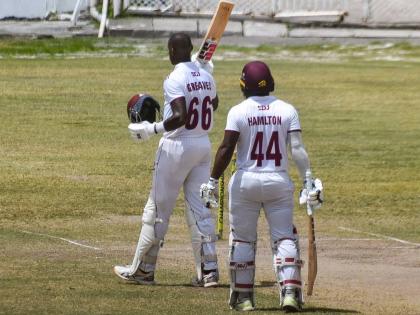 Leeward Islands Hurricanes batsman Justin Greaves (left) celebrates scoring a fighting century against the Trinidad and Tobago Red Force in a West Indies Championship cricket game at the Antigua Recreation Ground yesterday. With him is Jahmar Hamilton, who