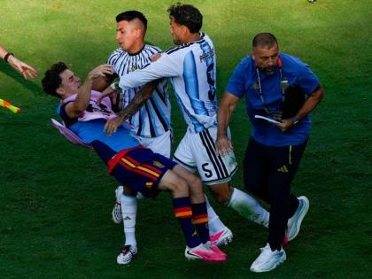 Spain's Gavi, left, falls as he scuffles with Argentina's Leandro Paredes (5) and Thiago Almada during the World Cup final football match between Spain and Argentina in East Rutherford, N.J., near New York, Sunday, July 19, 2026. (AP Photo/Yuki Iwamura)