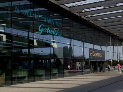 Passengers walk into the Departures entrance at the North Terminal of Gatwick Airport near Crawley, just south of London, on July 22, 2020. (AP Photo/Matt Dunham, File)