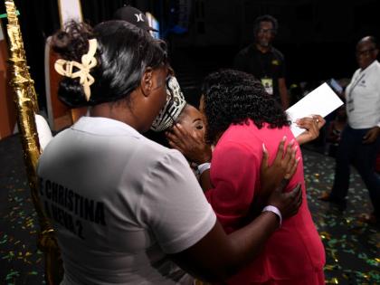 Christina Williams (centre), Miss Jamaica Festival Queen 2026, gets a kiss from her grandmother, Carmen Mcpherson (right) as her stepmother, Lasandra Williams (left), looks on during the coronation ceremony on Saturday night at Independence Village.